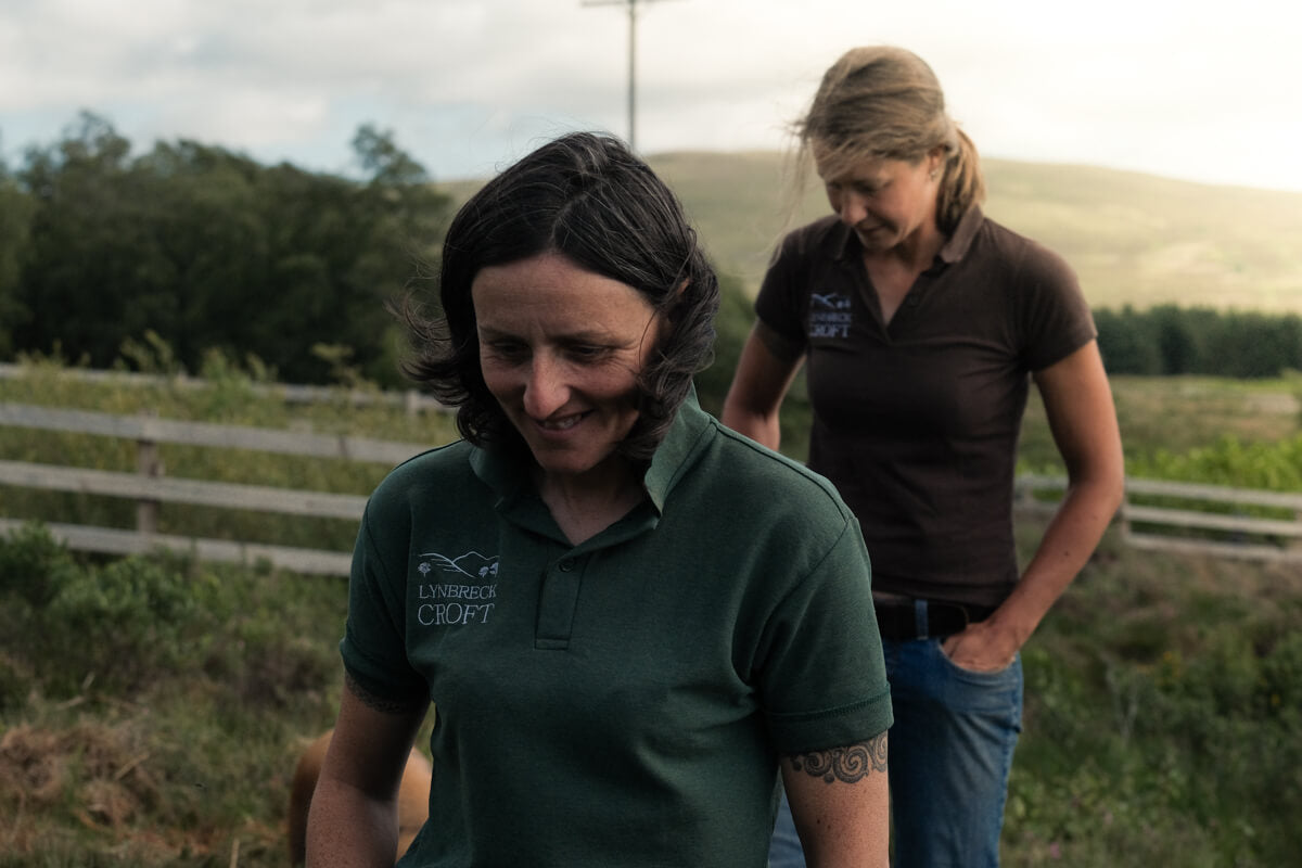 Lynbreck croft owners Lynn Cassells and Sandra Baer walking in field at sunset.